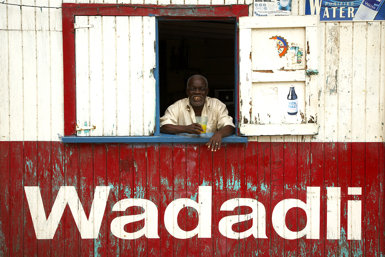 #070043-1 - Local Man in Window of Colourful Building, Antigua, Caribbean